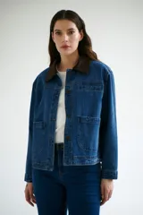 Chaqueta de jean azul con cuello de pana color camel, corte recto y bolsillos frontales.