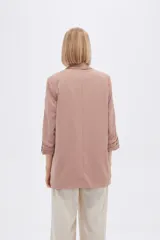 Blazer color rosa viejo, de corte recto, con solapas y mangas 3/4 con botón decorativo.