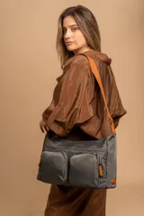 Bandolera de tafeta impermeable, liviana, con dos compartimientos principales, dos bolsillos con cierre y correa regulable con hebilla.