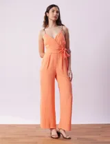 Enterito de crepe color naranja, marca Luxology. Escote en V cruzado, cintura elastizada con lazo de ajuste, espalda en punto smock y breteles de cadena.