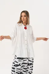 Camisa blanca con calados, escote en V, abotonada y manga 3/4.