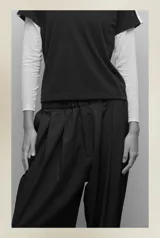 Pantalón sastrero negro de satén, con cintura elástica, tiro bajo, pinzas delanteras, bolsillos laterales y bolsillo ojal trasero.