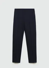 Pantalón de vestir color beige, de corte recto, con bolsillos laterales y traseros. Se ajusta a la cintura con cinturón de cuero marrón.