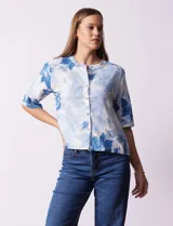Blusa de lino estampada con flores azules, marca Hester & Orchard. Cuello a la base y abertura central con botones.