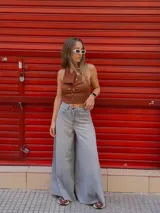 Pantalón de jean celeste de tiro medio con pierna extra ancha y caída fluida, con bolsillos delanteros y traseros, y cierre frontal con cremallera y botón metálico.