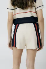 Short tejido en jersey color marrón con detalles de rayas verticales en color crema y ribete naranja.