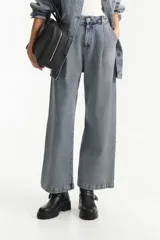 Pantalón de jean de tiro bajo, color azul claro con textura de rayas verticales sutiles. Presenta pinzas delanteras y un corte ancho y recto que llega hasta el tobillo.