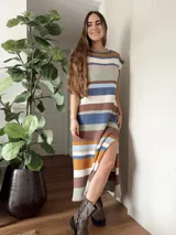 Vestido largo tejido con hilo de algodón en punto jersey rayado, con cuello redondo y mangas cortas. Diseño a rayas horizontales en tonos azul, marrón, beige y blanco. Hecho a mano con máquina de carro y terminaciones en crochet.