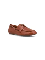 Mocasín náutico color marrón claro, confeccionado en 100% cuero, con cordones delgados en la parte superior y ojales metálicos en los laterales.