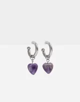 Aros dorados tipo argolla con dije colgante de cristal transparente en forma de corazón.