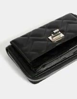 Billetera negra de cuerina con diseño acolchado, formato fichero, bolsillo frontal con broche y botón, cierre superior circundante y monedero interno con cierre.
