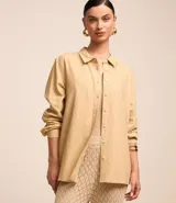 Camisa color beige de viscolino con cuello camisero, manga larga, botonadura frontal y corte holgado.