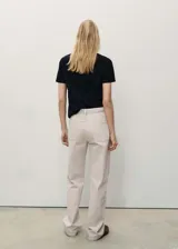 Pantalón de jean color crudo, corte recto, tiro medio, con cinco bolsillos y cierre frontal con cremallera y botón.