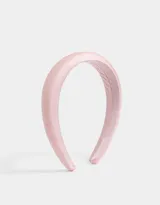 Vincha rígida color rosa claro, recubierta de tela satinada con efecto puffy.