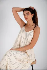 Vestido largo color crema con estampado geométrico lineal en negro, escote en V, breteles finos ajustables y bolsillos laterales.