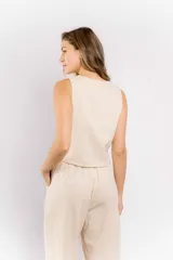 Chaleco color beige de lino con escote en V y cierre con botones.