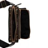Bandolera Guess modelo Saffron, color marrón con estampado del logo de la marca en tono café. Tiene correa bandolera ancha de lona negra con logo de la marca en blanco, cierre superior de cremallera, bolsillo frontal con cremallera y herrajes en tono níquel.