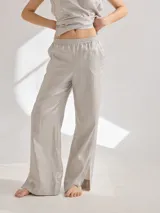 Pantalón de lino color gris claro, de corte recto con tajos laterales en el ruedo y cintura elastizada.