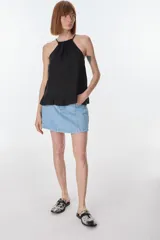 Musculosa color beige de lino, con cuello halter con volados y volados en el ruedo.