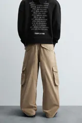 Pantalón cargo color beige, de corte relaxed fit, con bolsillos frontales, traseros con solapa y bolsillos laterales tipo parche con solapa.