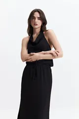 Musculosa blanca con detalle drapeado, cuello bote y espalda descubierta.