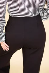 Pantalón de vestir negro con corte Oxford, tela suave al tacto con caída, cierre invisible y pinzas verticales. Confeccionado en 66% viscosa, 29% poliamida y 5% elastano.