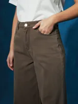 Pantalón de jean negro de tiro alto con corte ancho y pierna recta. Presenta costuras visibles y bolsillos tipo cinco bolsillos.