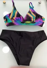 Conjunto de bikini con corpiño triangular con estampado animal print en tonos violeta y marrón, y bombacha tiro alto color lila.