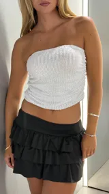 Top strapless blanco con textura de lentejuelas.