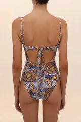 Traje de baño entero con estampado abstracto en tonos marrón, amarillo y celeste. Tiene breteles finos y escote recto con fruncido.