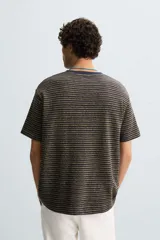 Camiseta de hombre de corte relaxed fit, con cuello redondo y mangas cortas. Diseño a rayas horizontales en tonos negro y dorado.