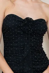 Vestido corto strapless negro con diseño drapeado y detalles de rhinestones.