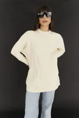 Sweater largo negro de tejido de punto con detalle de trama trenzada en el delantero.