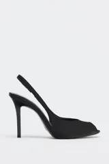 Zapato de tacón destalonado color negro con efecto satinado, punta fina, abertura delantera y tira trasera elástica. Tacón alto fino.