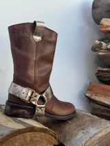 Bota de cuero marrón con estribo desmontable plateado.