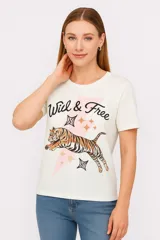 Remera blanca de algodón con estampado de un tigre, estrellas y la frase "Wild & Free".