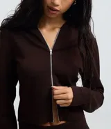 Campera corta de modal color azul, con capucha fija, mangas largas y cierre frontal de cremallera.