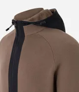 Cardigan de punto color marrón topo, con capucha negra contrastante y cierre frontal de cremallera negra. Presenta bolsillos laterales.