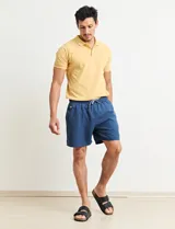 Chomba celeste con estampado de lunares blancos, cuello clásico y mangas cortas.