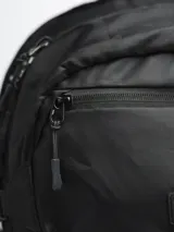 Mochila negra de poliéster ripstop, con compartimento principal amplio, bolsillo frontal con cierre, bolsillos laterales de malla, sistema de elástico frontal en forma de “8” y broches laterales de compresión.