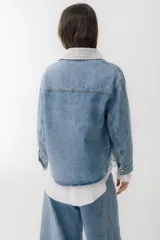 Campera de jean celeste con cuello y bolsillo con detalles de crochet blanco.