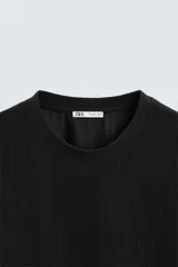 Camiseta de hombre color gris oscuro, de corte amplio, cuello redondo y manga corta.