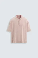 Polo de hombre color rosa, corte relaxed fit, tejido de punto con textura bouclé y mezcla de algodón. Tiene cuello solapa, cierre frontal con botones, manga corta y acabados en rib.