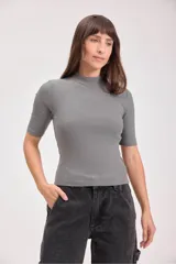 Remera gris de punto con cuello alto y mangas cortas.