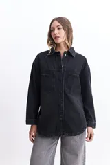 Campera de jean celeste de corte holgado, con cuello camisero, cierre frontal con botones metálicos, mangas largas con puños abotonados, bolsillos frontales con solapa y costuras a la vista.