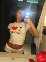 Remera blanca de algodón con mangas cortas y cuello redondo. Estampado frontal con la frase "I ❤️ Latinas" en color negro y rojo.