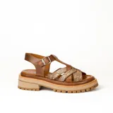 Sandalias bajas de cuero vacuno color beige con tiras cruzadas plateadas y hebilla lateral. Suela doble de goma deportiva con altura de 3cm adelante y 5,5cm atrás.