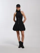 Top negro de lycra con escote halter, silueta entallada al cuerpo con ballenas, forrado con tejido tipo remería y espalda semi descubierta con cierres a la vista.