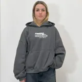Buzo hoodie negro de felpa con calce boxy fit y estampa frontal con el texto "Feeling" en blanco.