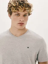 Pijama de dos piezas compuesto por remera manga corta gris con cuello en V y bordado de logo en el pecho, y short negro.